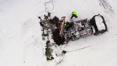 Truck digging hole for utility pole in winter, aerial zoom in Stock Footage 228356450