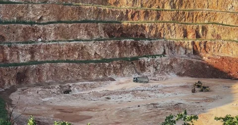 Truck drive on mining hillside with a large pit in the middle Stock Footage 294973546