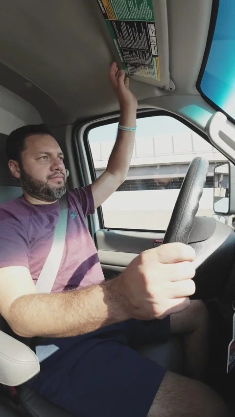 Truck driver adjusting sun visor while driving Stock Footage 292728036