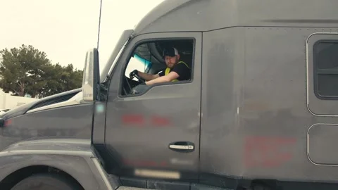 Truck driver looking at camera from semi truck cabin Stock-Footage 347100012