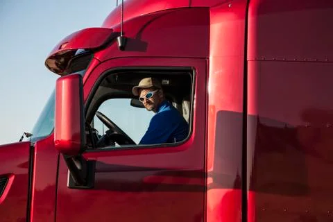 Truck driver, man in a red lorry cab. Stock Photos