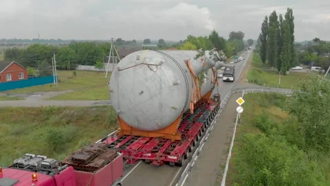 A truck driver with an oversized cargo drives along an intercity highway. 库存影片 147536751