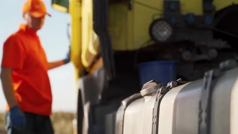 Truck driver refuels a fuel tank with diesel filling gun intruck at petrol Stock Footage 201150733