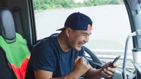 The truck driver is using a smartphone. Foto stock