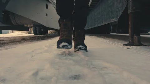 Truck driver walking in the snow between two semi trailers Stock-Footage 347100134