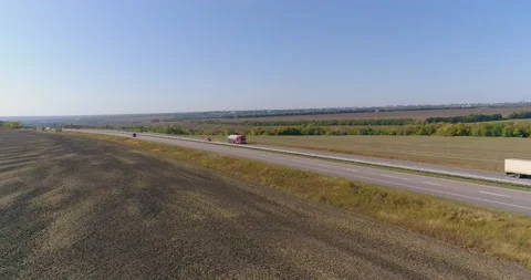 The truck drives on the road, fields in the background. The truck drives along Stock Footage 166085551
