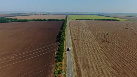 A truck drives through the fields in sunny, summer weather. Concept of trucking Stock Footage 143497024