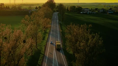 Truck driving on empty highway through countryside at sunset. Freight lorry Stock Footage 316311196