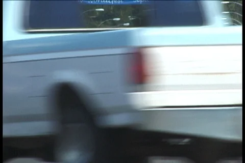 Truck with Flags Fluttering above Flatbed Driving down Libby Street Stock Footage 121555576