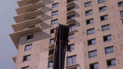 Truck mounted crane lifting construction materials beside apartment building Stock Footage 344606744