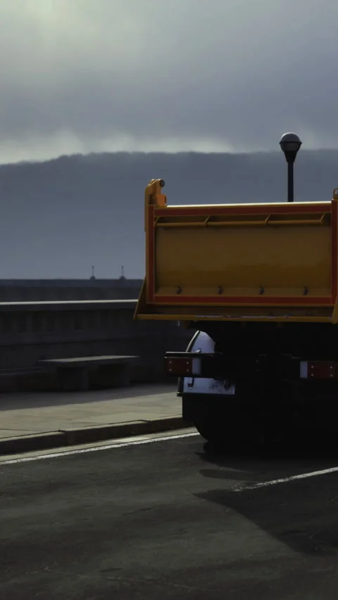 Truck parks on road under cloudy sky near waterfront at dusk Stock Footage 334884776