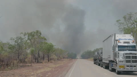Truck Road Train driving through Australia Outback Bush Fire - Smoke &amp; Flames Stock Footage 263249601
