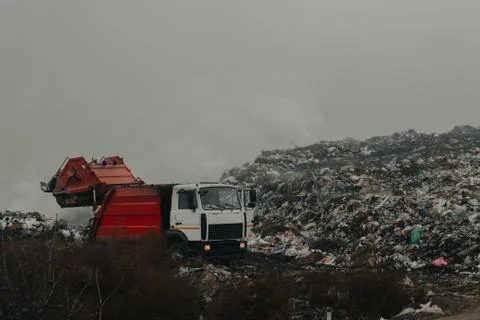 Truck throws garbage in an open garbage dump Stock Photos