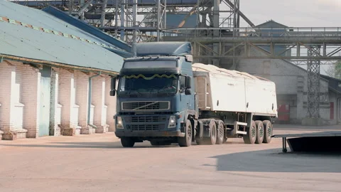 A truck with a trailer full of grain pulls into a grain and seed processing and Video stock 247398294
