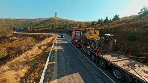 Truck trawl trailer with mining loader, FPV drone view in mountains 4K Stock Footage 234581552