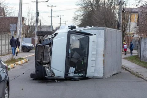 The truck is turned on its side and is lying on the street. Accident. Stock Photos