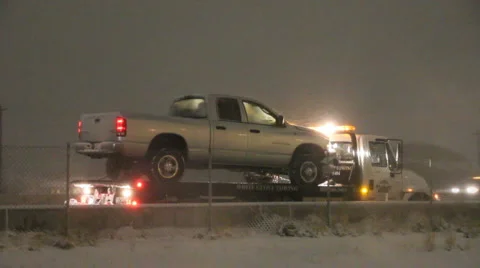Truck on a wrecker in a snow storm HD2816 Stock Footage