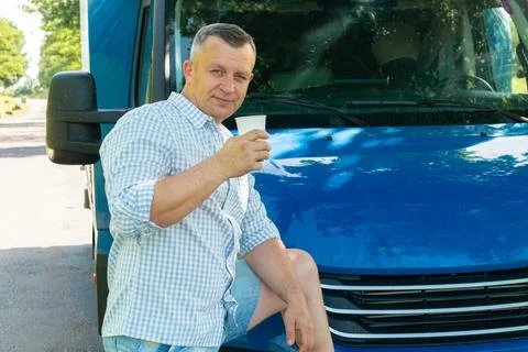 Trucker drinking coffee during break on road 스톡 사진