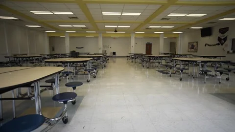 Trucking view to right showing empty school cafeteria with tables and seats. Stock Footage 246867028