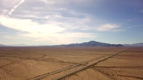 Trucks and cars driving across road in desert Arizona, drone, aerial Stock Footage