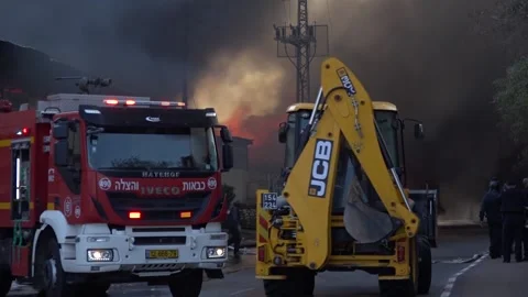 Trucks and firefighters working on a fire product of a gaza rocket Stock Footage 145867142