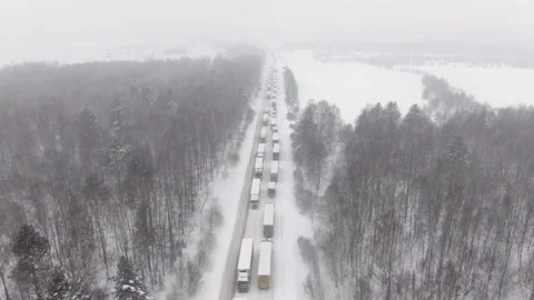 Trucks are stuck in traffic on a snow-covered highway. Stock Footage