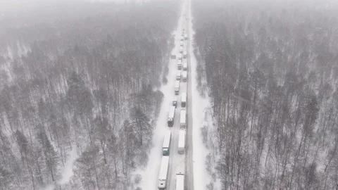 Trucks are stuck in traffic on a snow-covered highway. Stock Footage