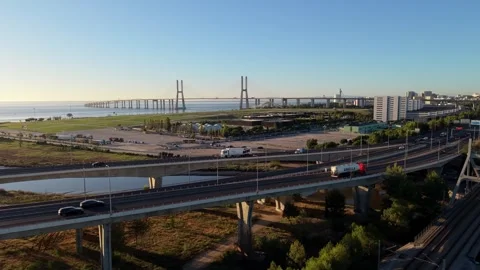 Trucks drive along multi-level highways near long suspension bridge Stock Footage 345226532
