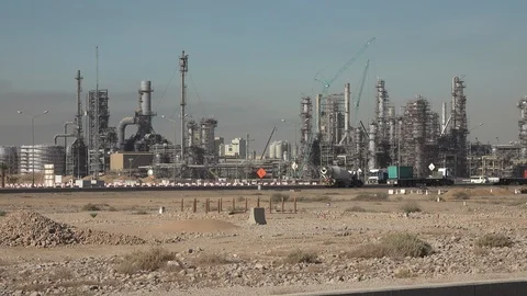 Trucks drive past oil refineries and petrochemical facilities Saudi Arabia Stock Footage