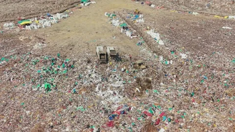 Trucks Dumping Waste As A Crane Pushes And Levels Garbage At A Dump Yard Stock Footage 341462472