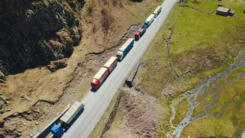 Trucks forming a long queue and waiting to pass the border between Georgia and Stock Photos