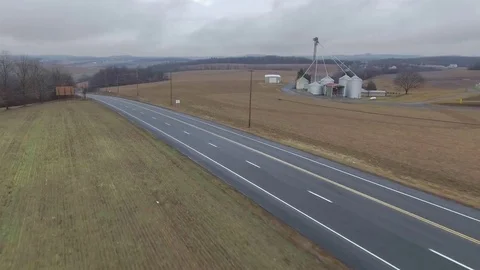 Trucks going down hill in the countryside on a cloudy day Stock Footage 71760631
