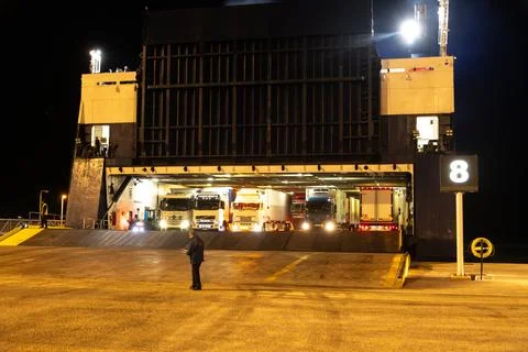 Trucks Loading Through Open Ferry Ramp at Night Photos
