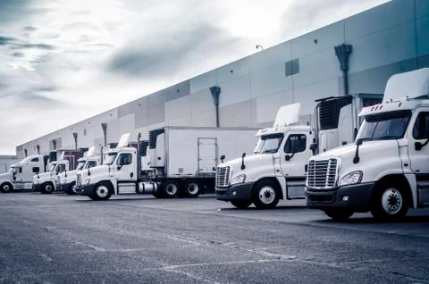 Trucks lorrys loading unloading at warehouse Stock Photos