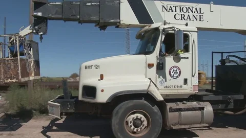 Trucks move as a crane is positioned to lift huge electric pole, 4K. Stock Footage 80931236