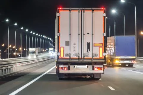 Trucks move on a night freeway Stock Photos