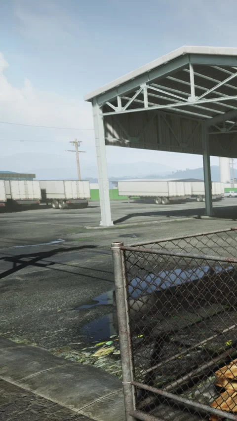 Trucks parked under a shelter at a loading area near an open field Video stock 338002315