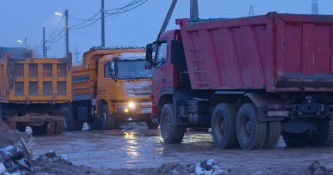 Trucks with their headlights on are driving on a muddy road Stock Footage 147624280