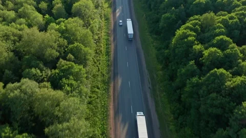 Trucks with trailers go one after another on the asphalted track, rear view Stock Footage 157925184
