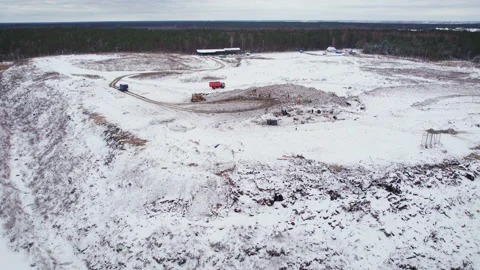 Trucks unloading garbage riding on top of a pile in a landfill in a wooded area Stock Footage 235480913