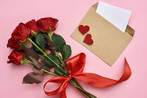 True love. Envelope with paper note, bouquet of roses with red ribbon Stock Photos