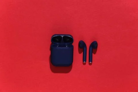 True wireless bluetooth headphones or earbuds with charging case on bright re Stock Photos