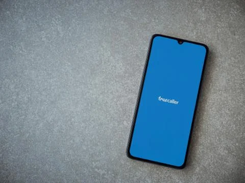 Truecaller app launch screen with logo on the display of a black mobile smart Stock Photos