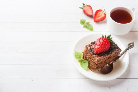 Truffle cake with chocolate and strawberries and mint on a white wooden tab.. 스톡 사진