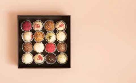 Truffles in a box on a pink background. Assorted candies or energy balls. Hom Stock Photos