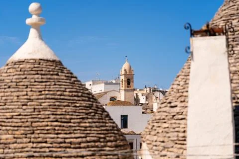 Trulli rooftops with bell tower in the background Foto stock