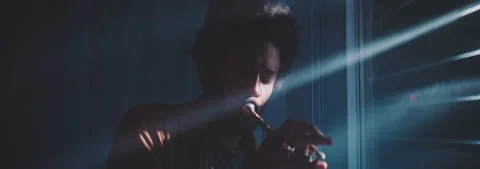 A trumpeter playing in a dark room with rays of light filtering through the Stock Footage 202309286