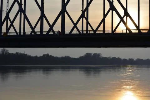 Truss bridge span against sunset reflecting on the water Stock Photos