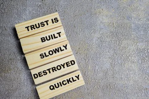 Trust built slowly destroyed quickly on stacked wooden cubes on the table. Stock Photos