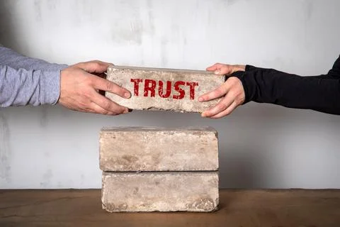 Trust concept. White brick stack on a wooden table Stock Photos